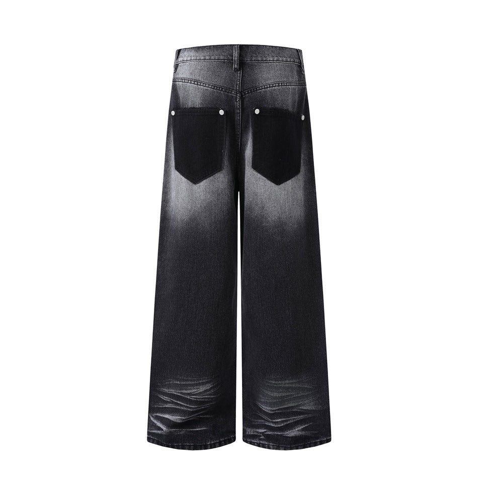 Back view of wide-leg charcoal-black jeans with contrasting dark back pockets and faded hems.