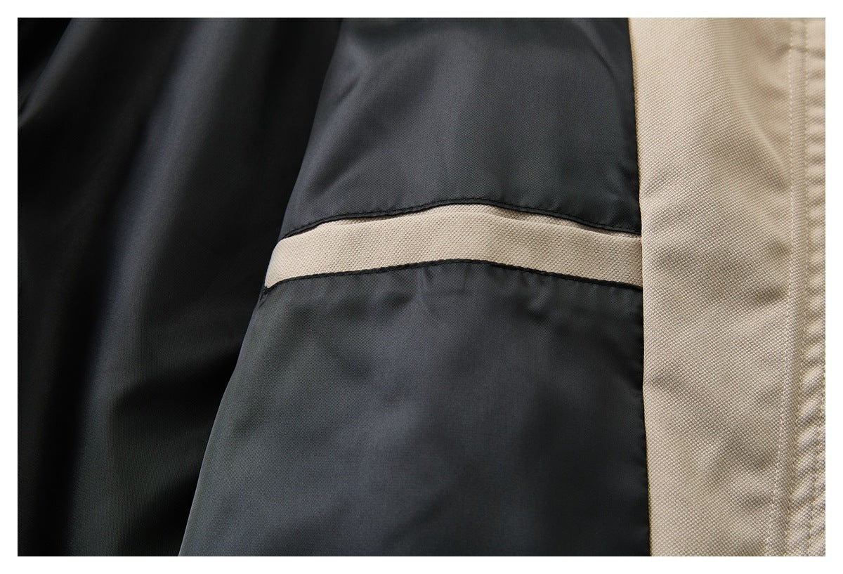 Close-up of dark charcoal garment fabric with a narrow beige stripe and a beige side panel.