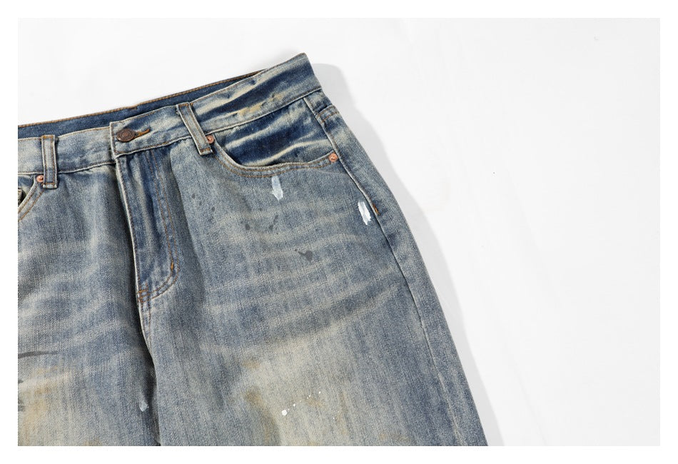Close-up of a front pocket and waistband on faded blue jeans, showing small distressed marks.