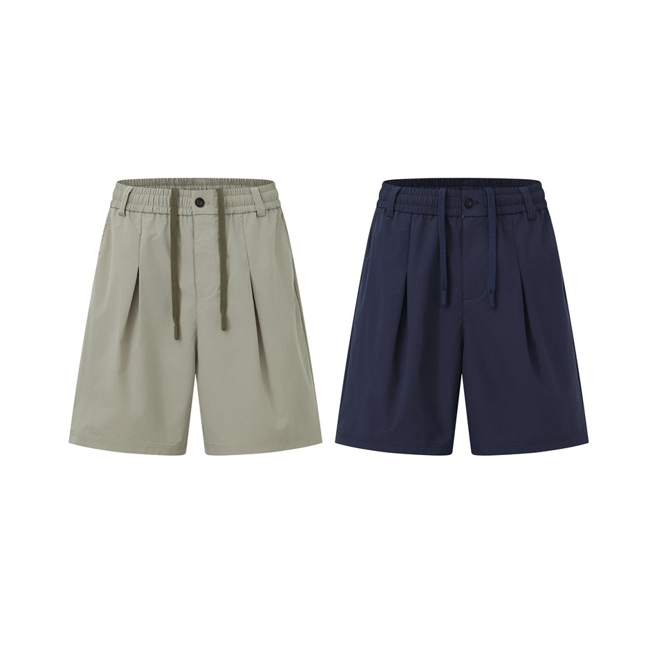 Two pairs of loose shorts shown from the front in light gray and navy, both with elastic waistbands and drawstrings.