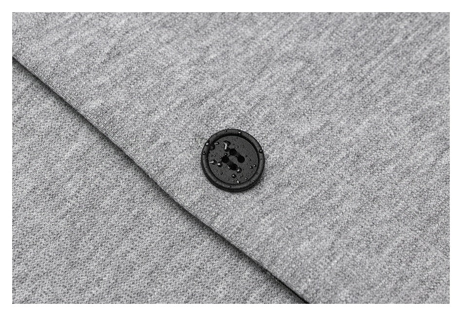 Close-up of a black button on overlapping heather-gray garment fabric.
