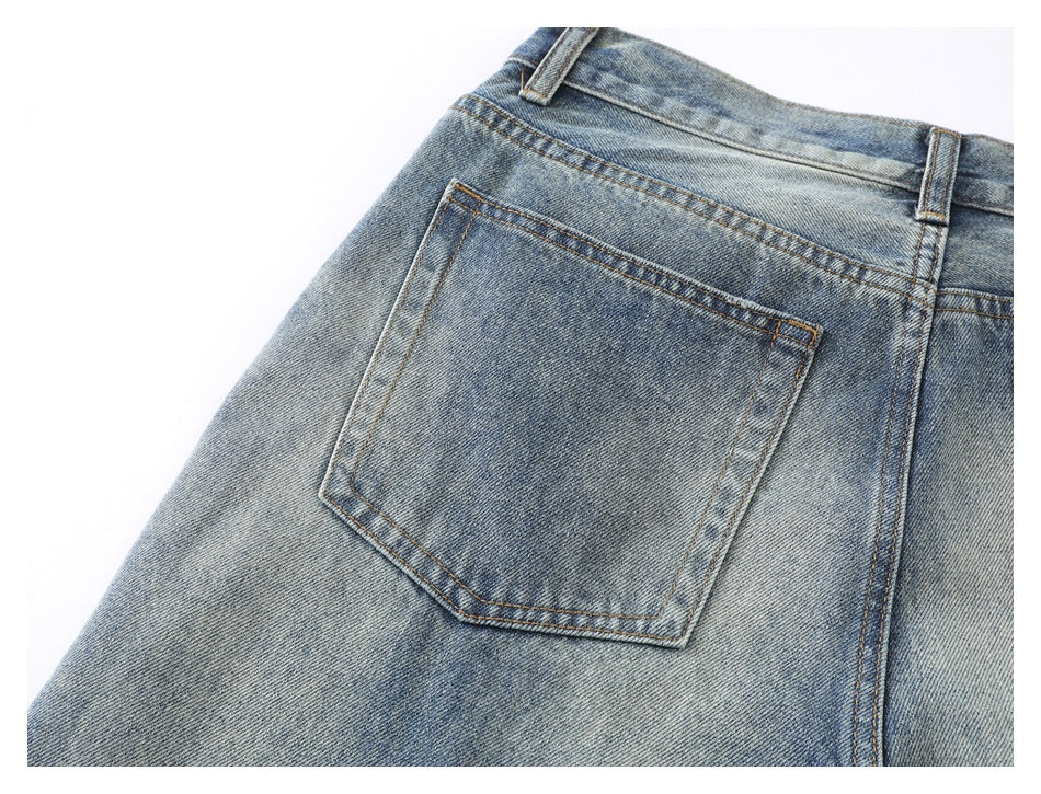 Close-up of the back of blue faded jeans, showing a patch pocket, waistband and belt loops.