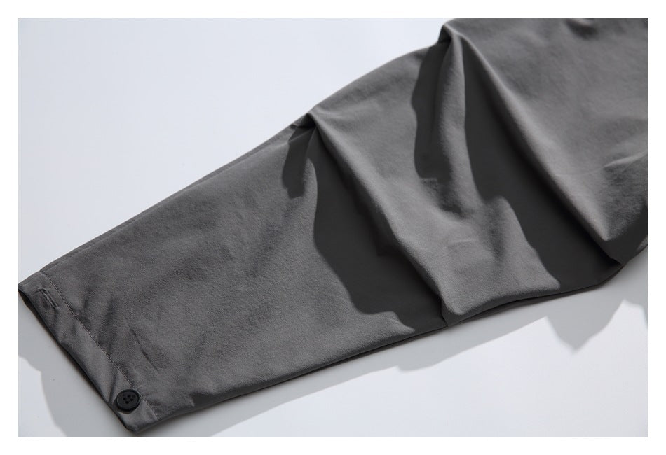 Close-up of a charcoal gray sleeve ending in a cuff with a dark button.