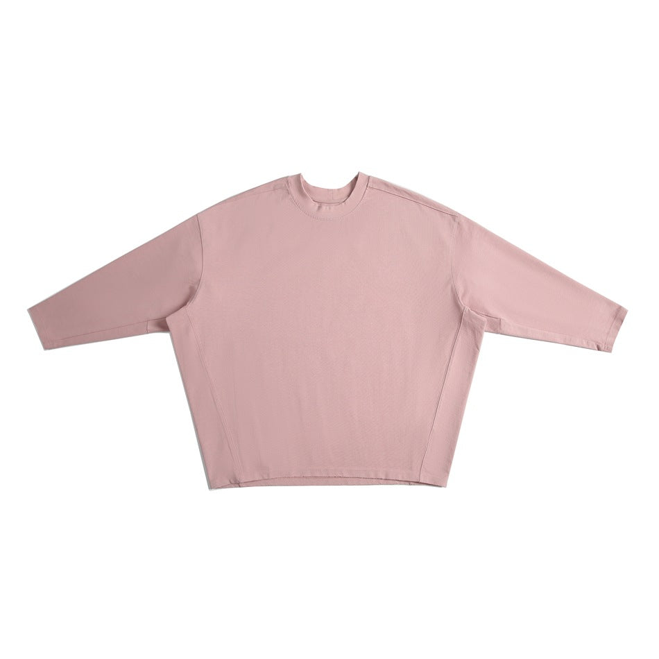 Pink long-sleeve crew-neck oversized top with batwing sleeves and curved side seams, flat lay front view