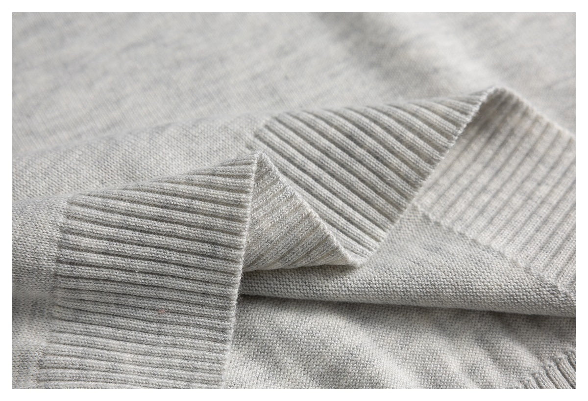 Close-up of the polo's light gray ribbed sleeve cuff and knit fabric.