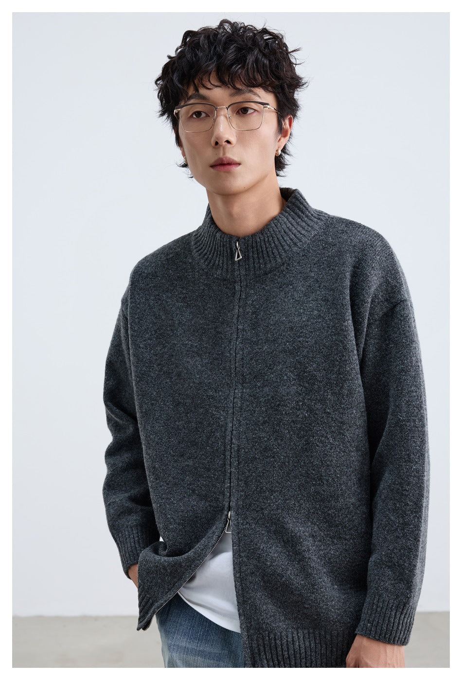 Close view of a model wearing a charcoal gray cardigan, showing its ribbed collar and metal zipper pull.