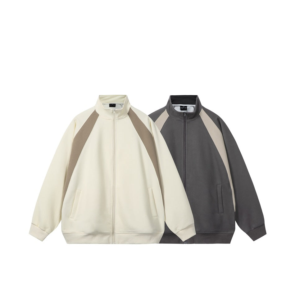 Two front views of zip-up jackets with stand collars and contrast shoulder panels: ivory and taupe, and charcoal and beige.