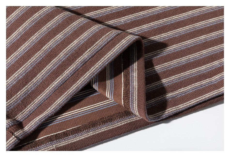 Close-up of the brown striped knit shirt's folded sleeve and stitched hem.