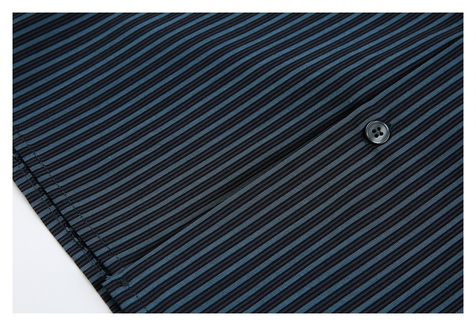 Close-up of a black button on the black and blue striped shirt, with a stitched edge visible.