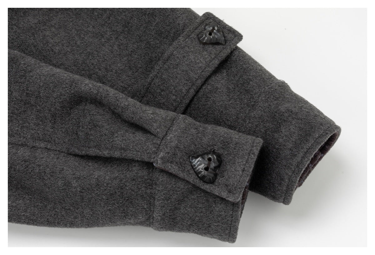 Close-up of a dark charcoal coat sleeve and buttoned cuff.