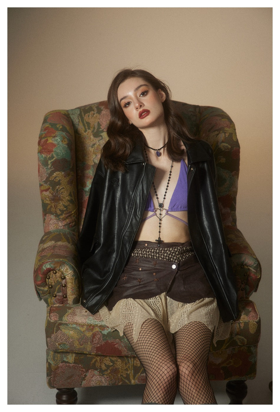 Front view of a model wearing an open black jacket with a wide collar and long sleeves.
