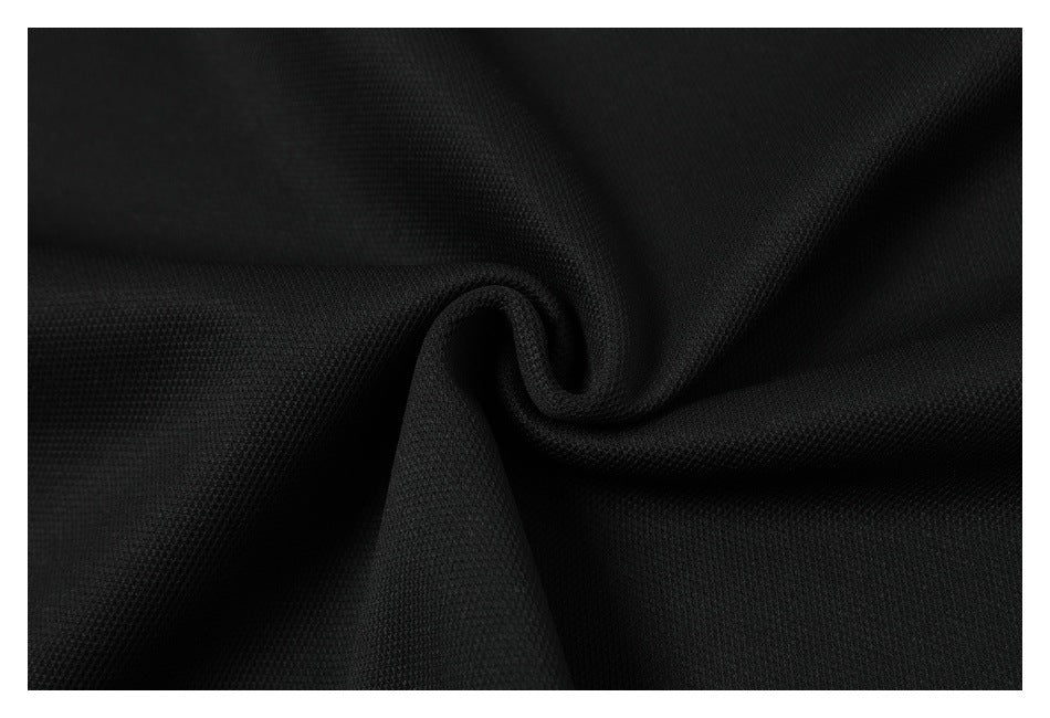 Close-up of black textured fabric gathered into a soft spiral fold.