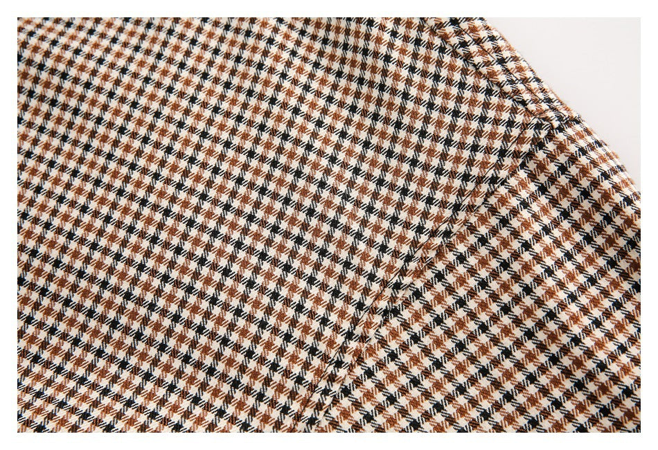 Close-up of brown, black, and cream houndstooth fabric with a stitched seam.