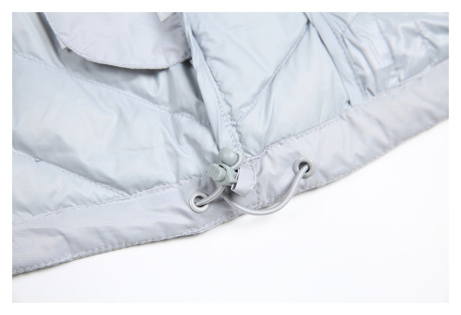 Close-up of a pale gray padded jacket hem with a cord, eyelets, and an adjustable toggle.