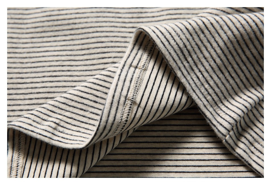 Close-up of the striped garment's folded edge and overlocked seam stitching.