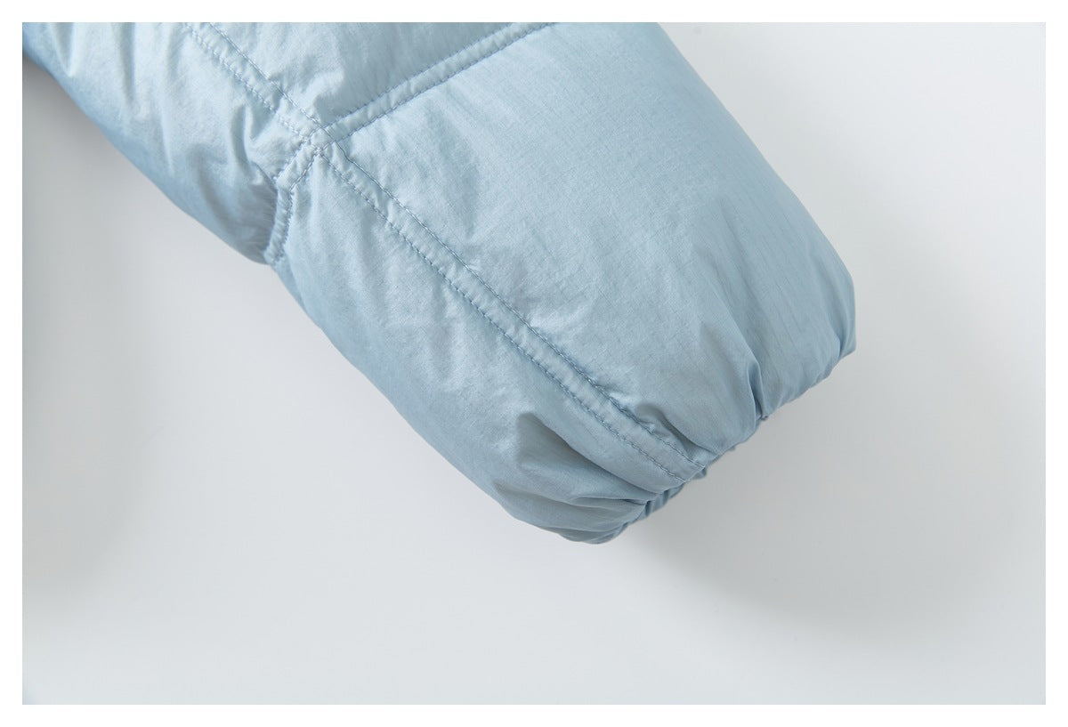 Close-up of a pale blue jacket sleeve showing angled stitched seams and a gathered edge.