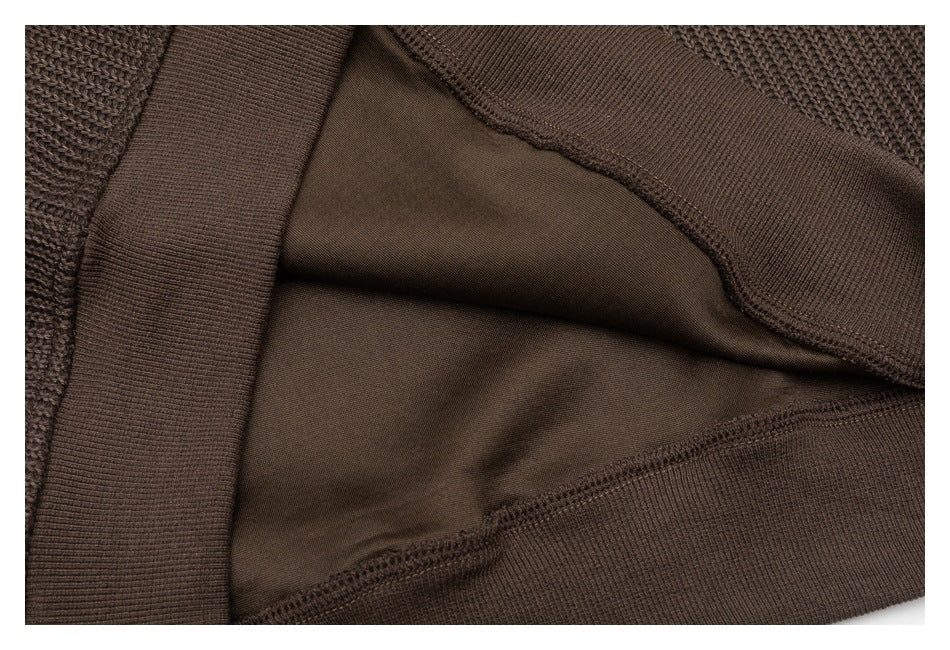 Close-up of the dark brown sweater's inner fabric and ribbed hem construction.