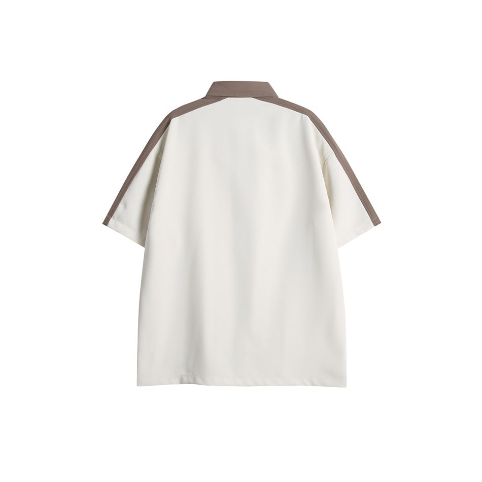 Back view of an ivory short-sleeve shirt with taupe collar and shoulder trim.