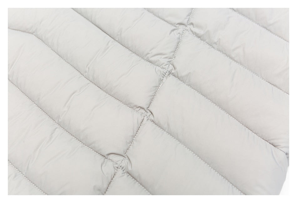 Close-up of light gray quilted jacket fabric with diagonal stitched channels.