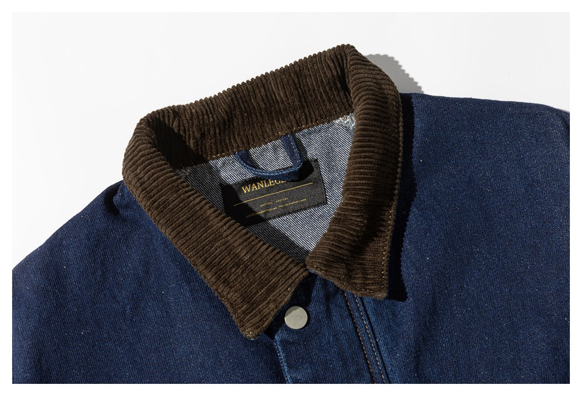 Close-up of a dark blue denim jacket's brown corduroy collar, snap, and sewn-in neck label.