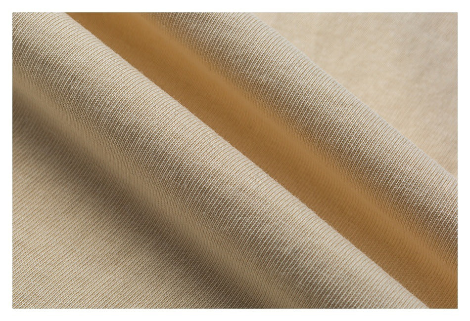Close-up showing the soft-looking knit texture and folds of beige T-shirt fabric.
