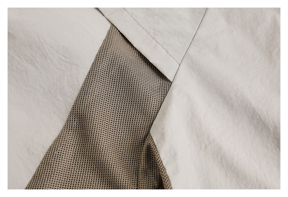 Close-up of a brown open-mesh garment panel between sections of light beige fabric.