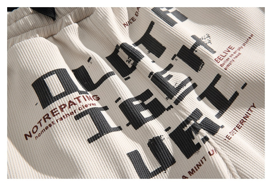 Close-up of cream ribbed fabric featuring oversized black lettering and smaller brown text.