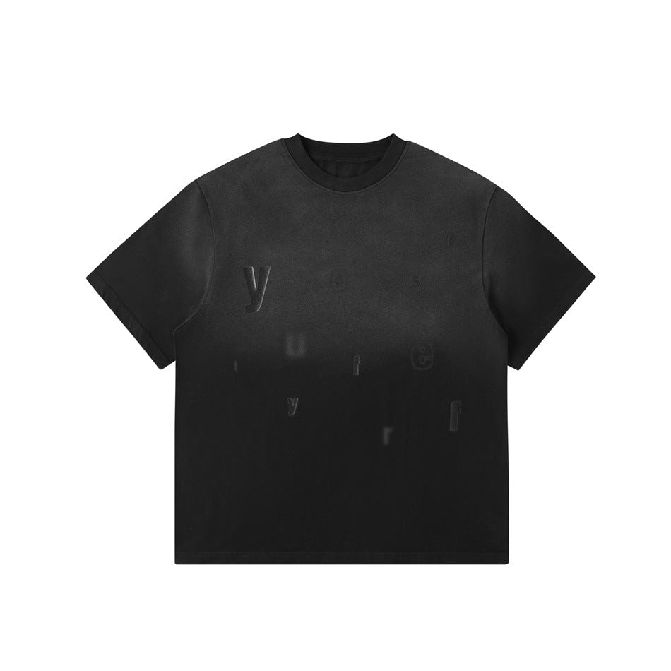 Black washed gradient crew-neck T-shirt with scattered tonal raised letters on the front, flat lay