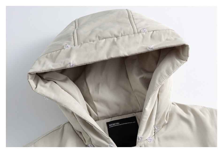 Close-up of an ivory hood with stitched panels and clear snap fasteners.