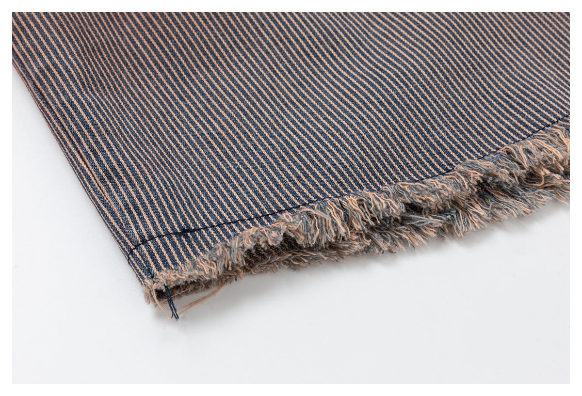 Close-up of the shirt's navy and rust diagonal-striped fabric and frayed hem.