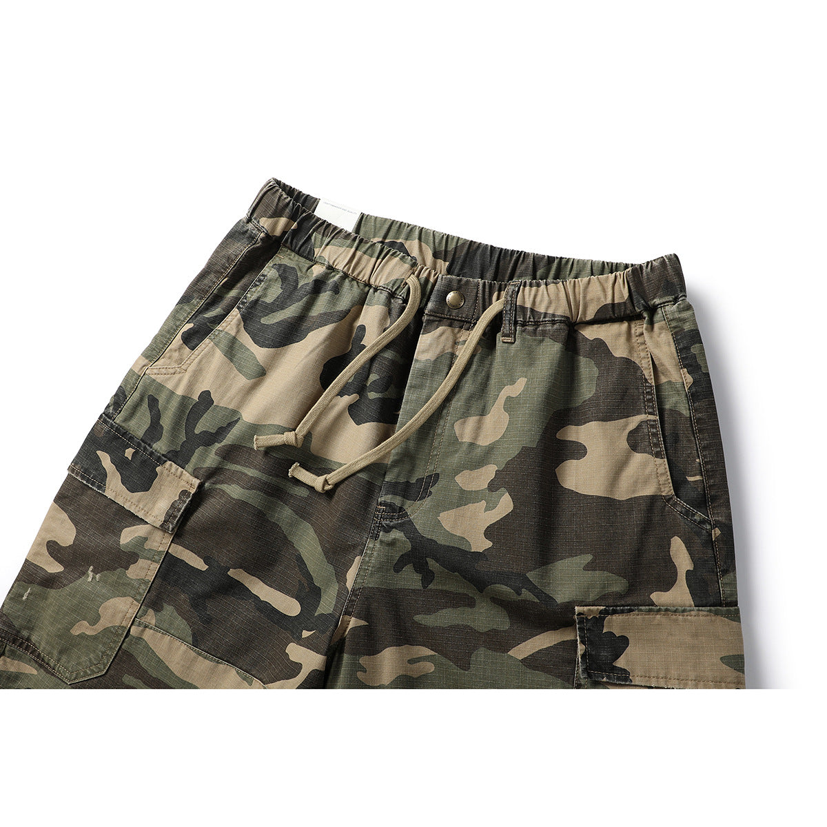 Close-up of camouflage cargo shorts showing the elastic waist, drawstring, front button, and pockets.