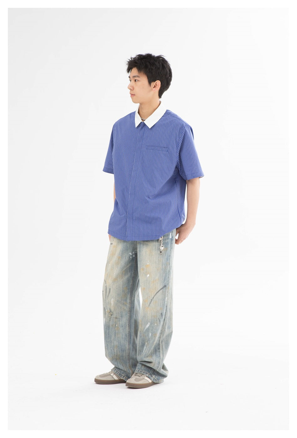 Model in blue striped short-sleeve shirt with white collar and light-wash distressed jeans, side view