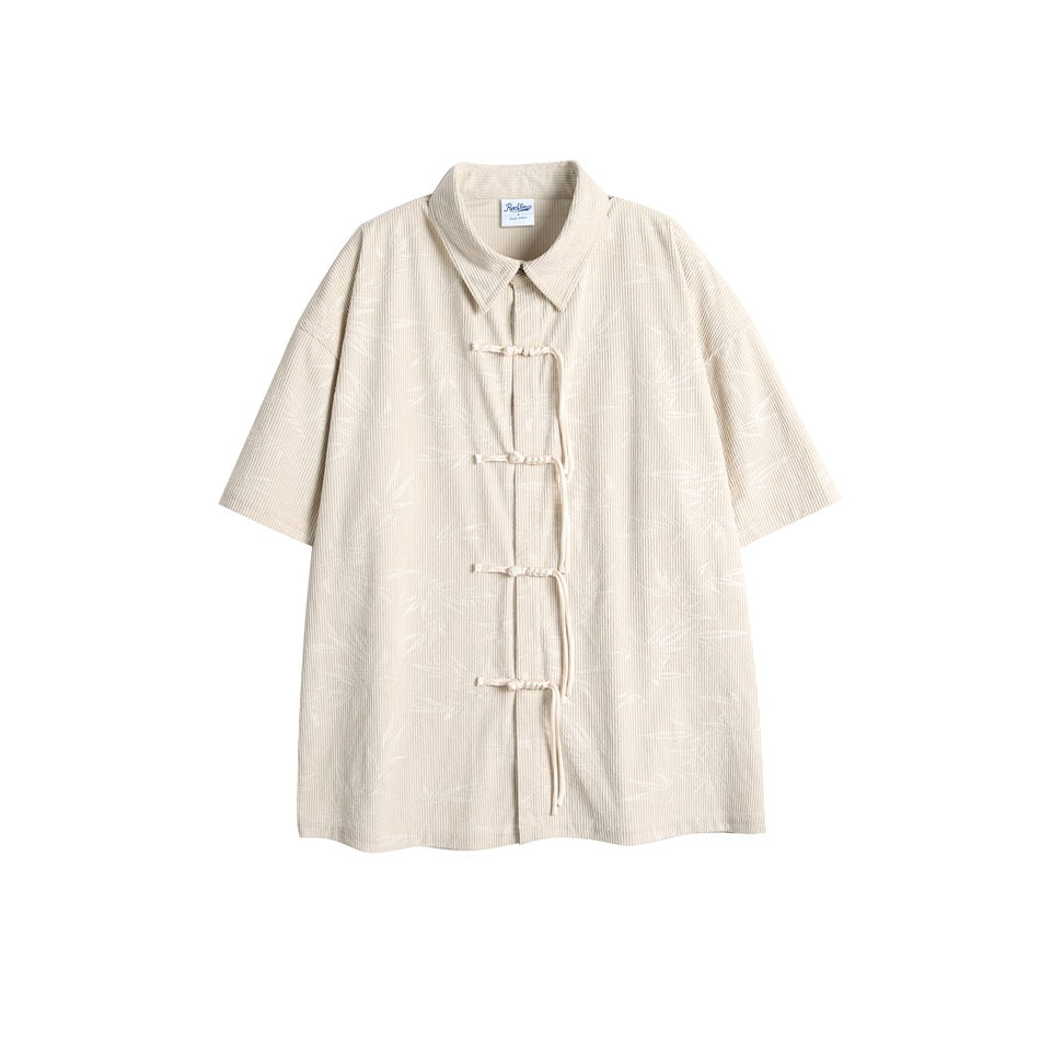 Apricot short-sleeve ribbed shirt with bamboo-leaf print and knotted frog-button front closure, flat lay