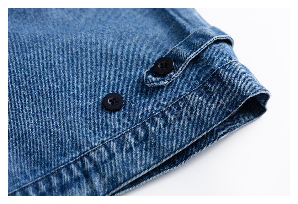 Close-up of a blue denim cuff with two dark buttons and visible stitching.