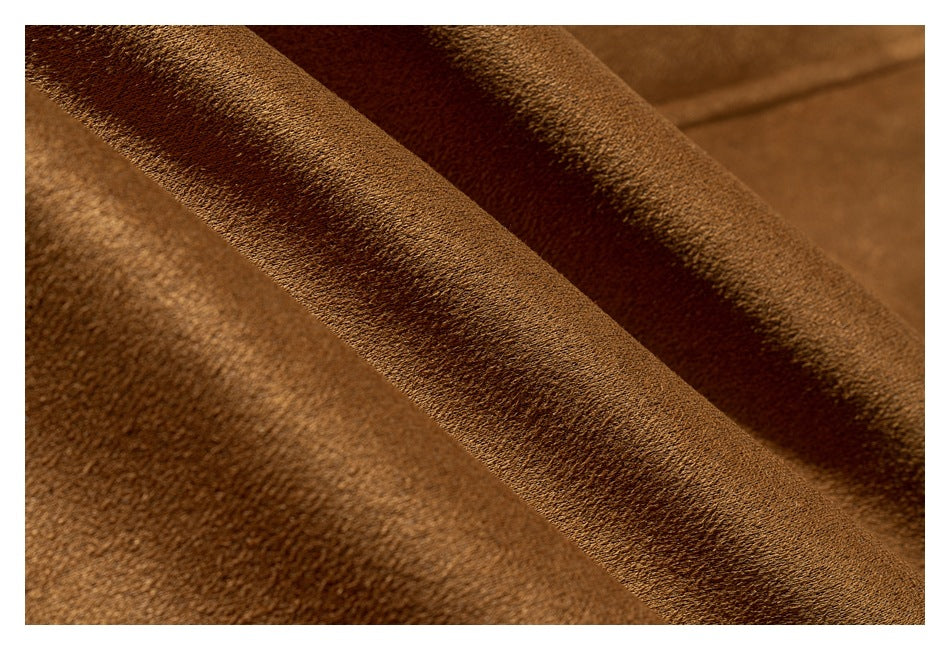 Extreme close-up of the camel-brown coat's textured fabric and folded edge.