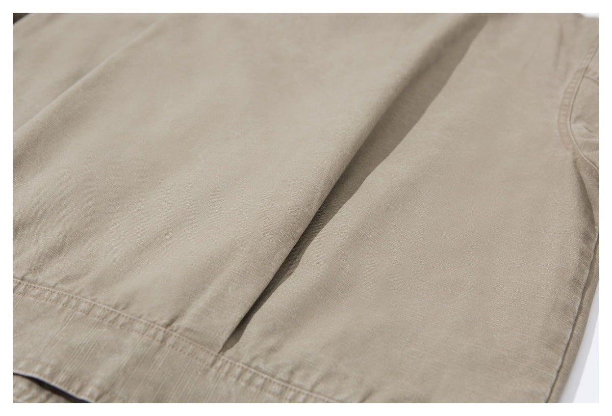 Close-up of beige garment fabric showing a folded panel and stitched hem.