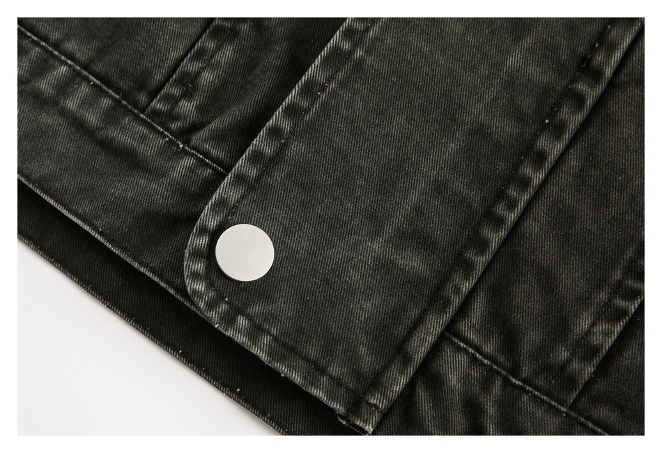 Close-up of a silver snap on a dark washed jacket pocket flap with visible stitching.