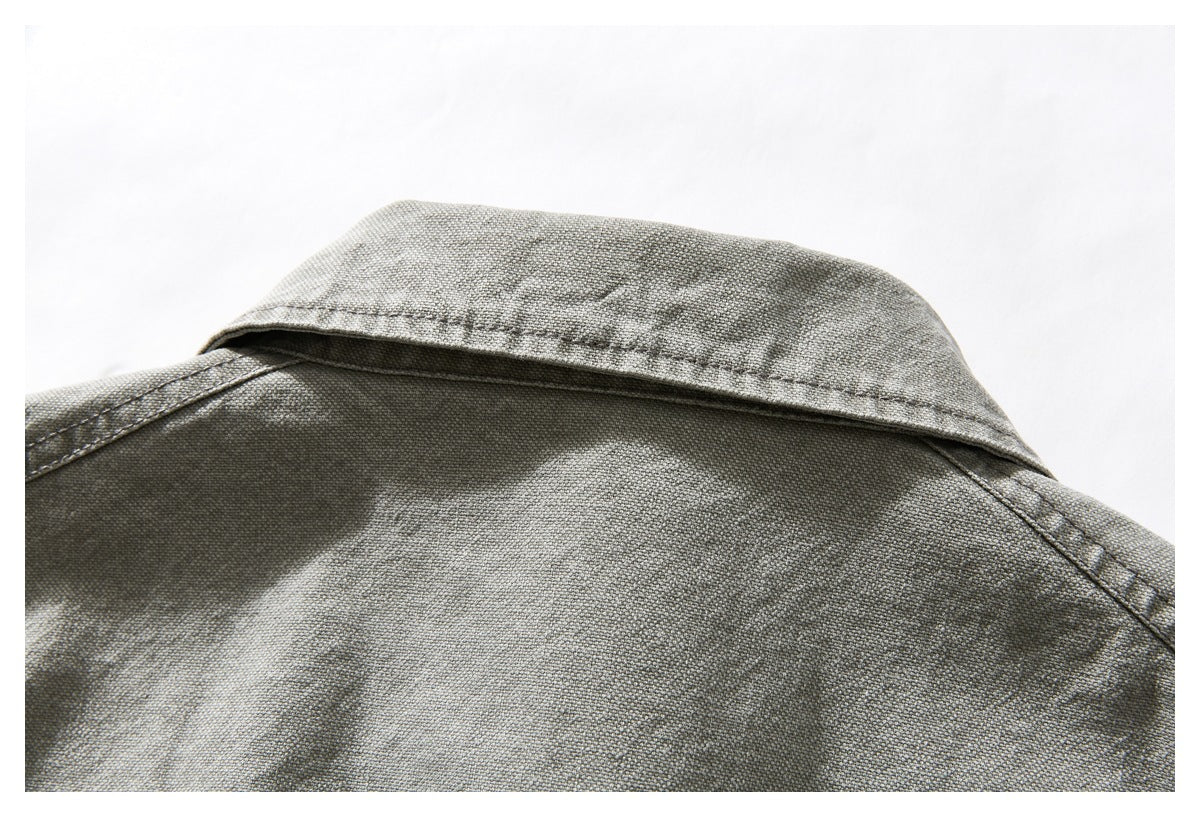 Close-up of the gray-green jacket's folded collar and upper back stitching.