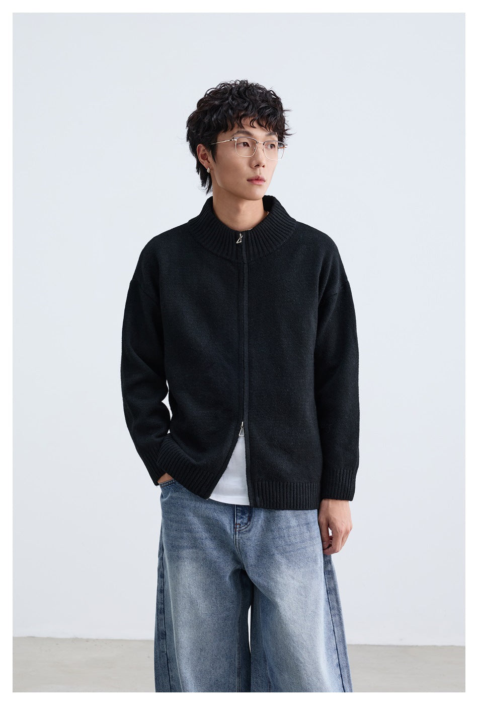Close view of a model wearing a black zip-front cardigan with a ribbed stand collar and cuffs.