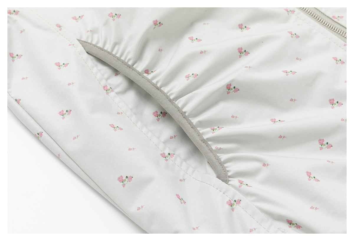Close-up of the jacket’s slanted pocket opening, gray trim, and pink floral print.