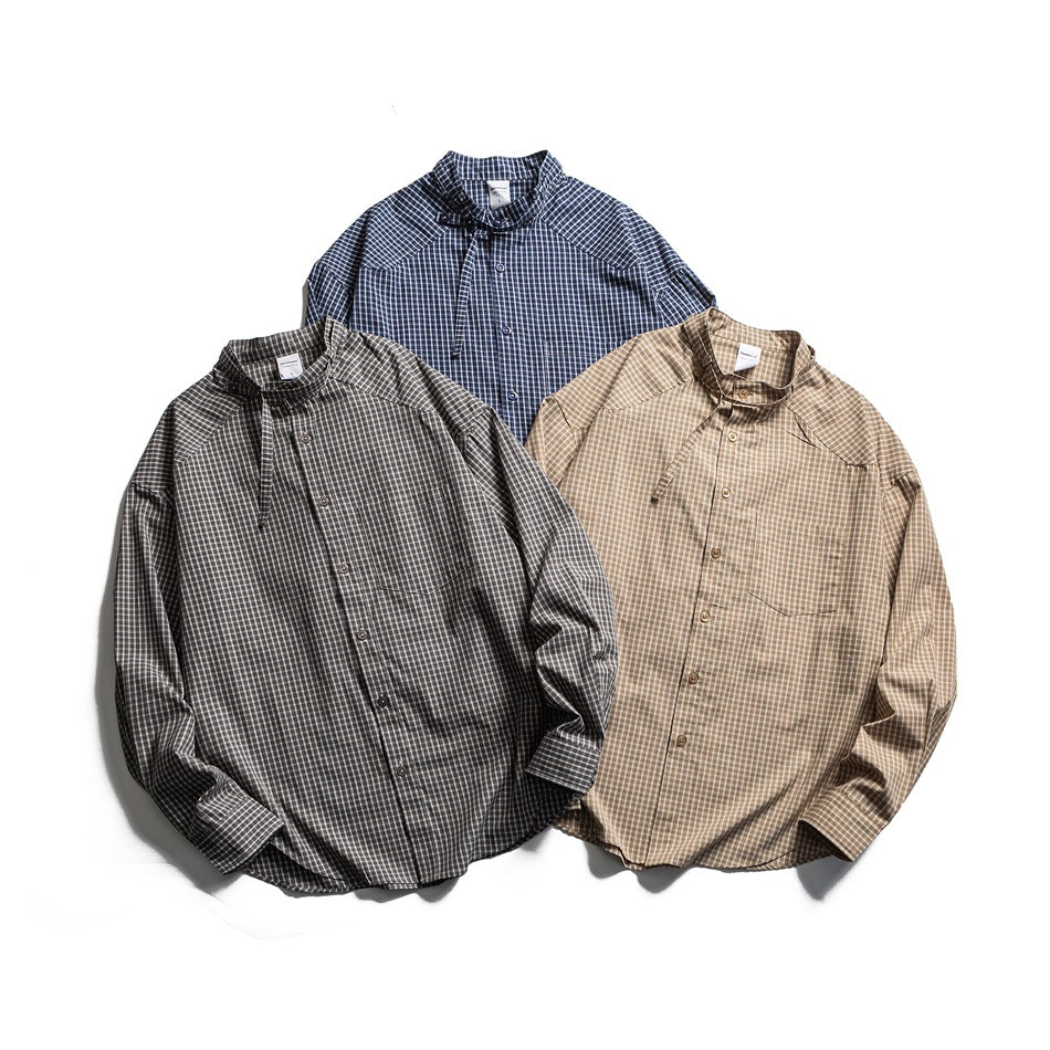 Three long-sleeve button-front plaid shirts laid flat in navy, gray, and tan colorways.