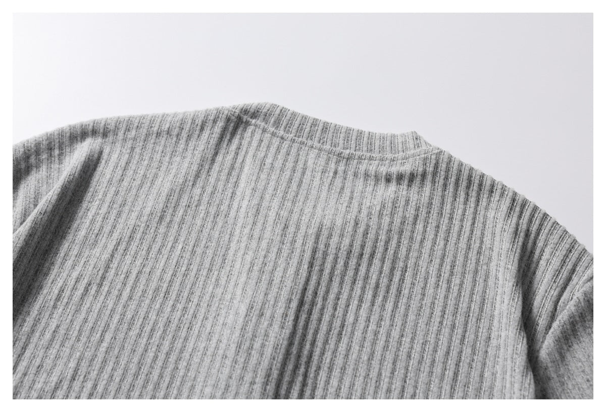 Cropped view of the upper back and shoulders of a heather gray ribbed garment.