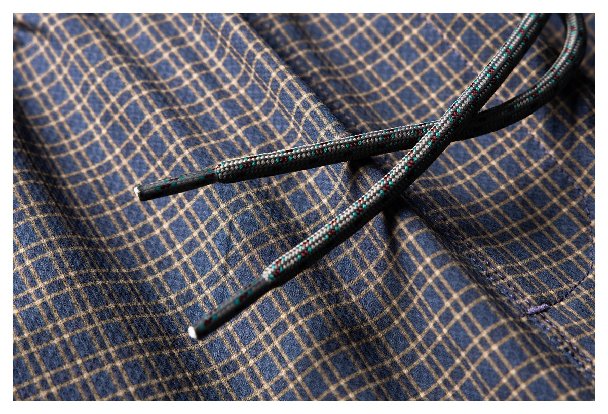 Close-up of navy and tan plaid fabric with braided drawstrings.