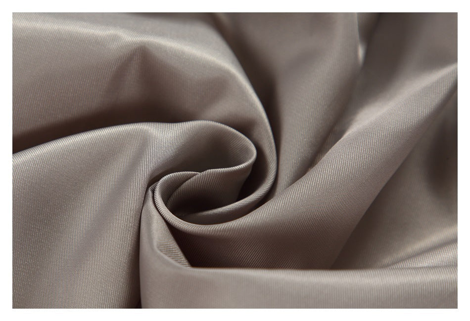 Macro view of smooth taupe-gray jacket lining gathered into soft folds.