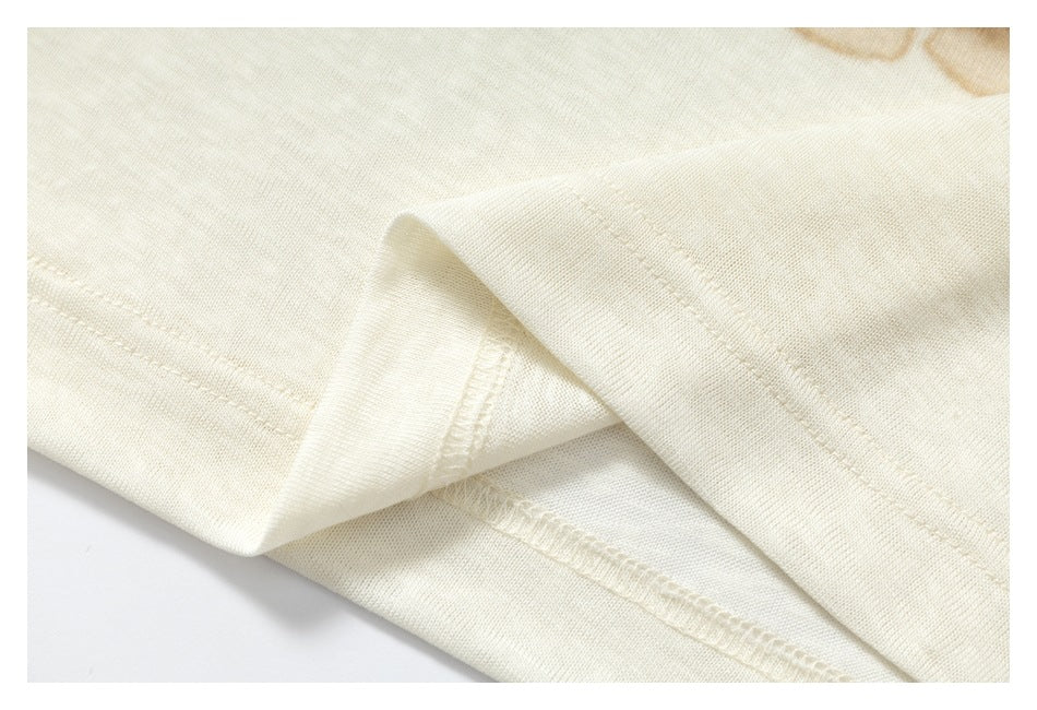 Close-up of folded ivory fabric showing the hem stitching and inner seam.