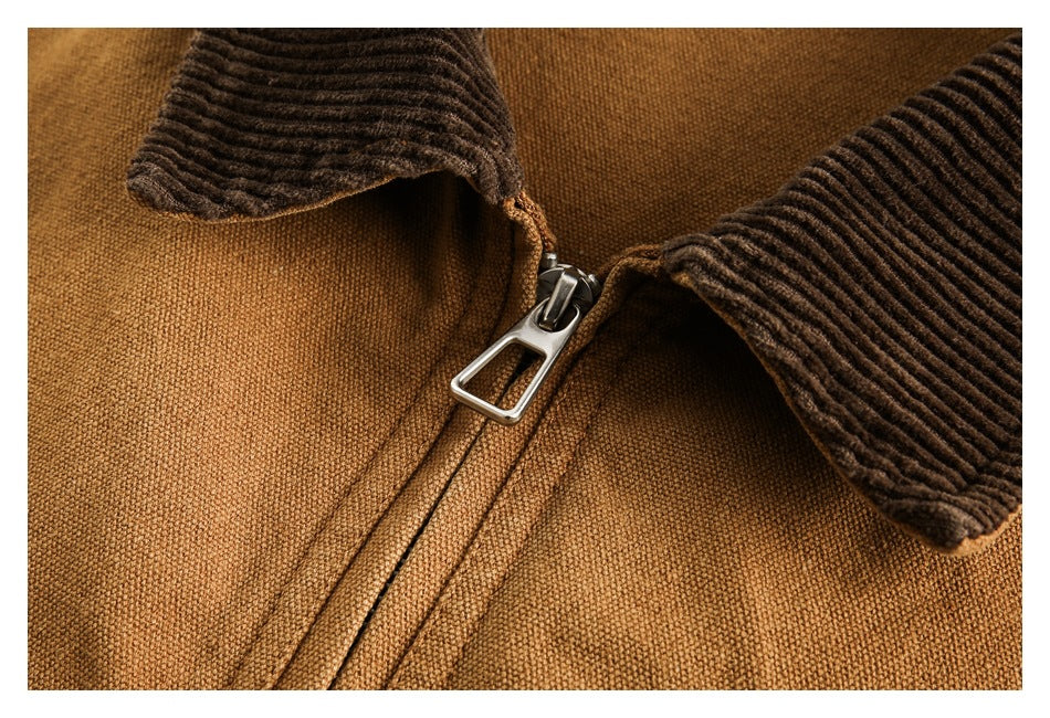 Close-up of the tan jacket's central metal zipper beneath the brown corduroy collar.