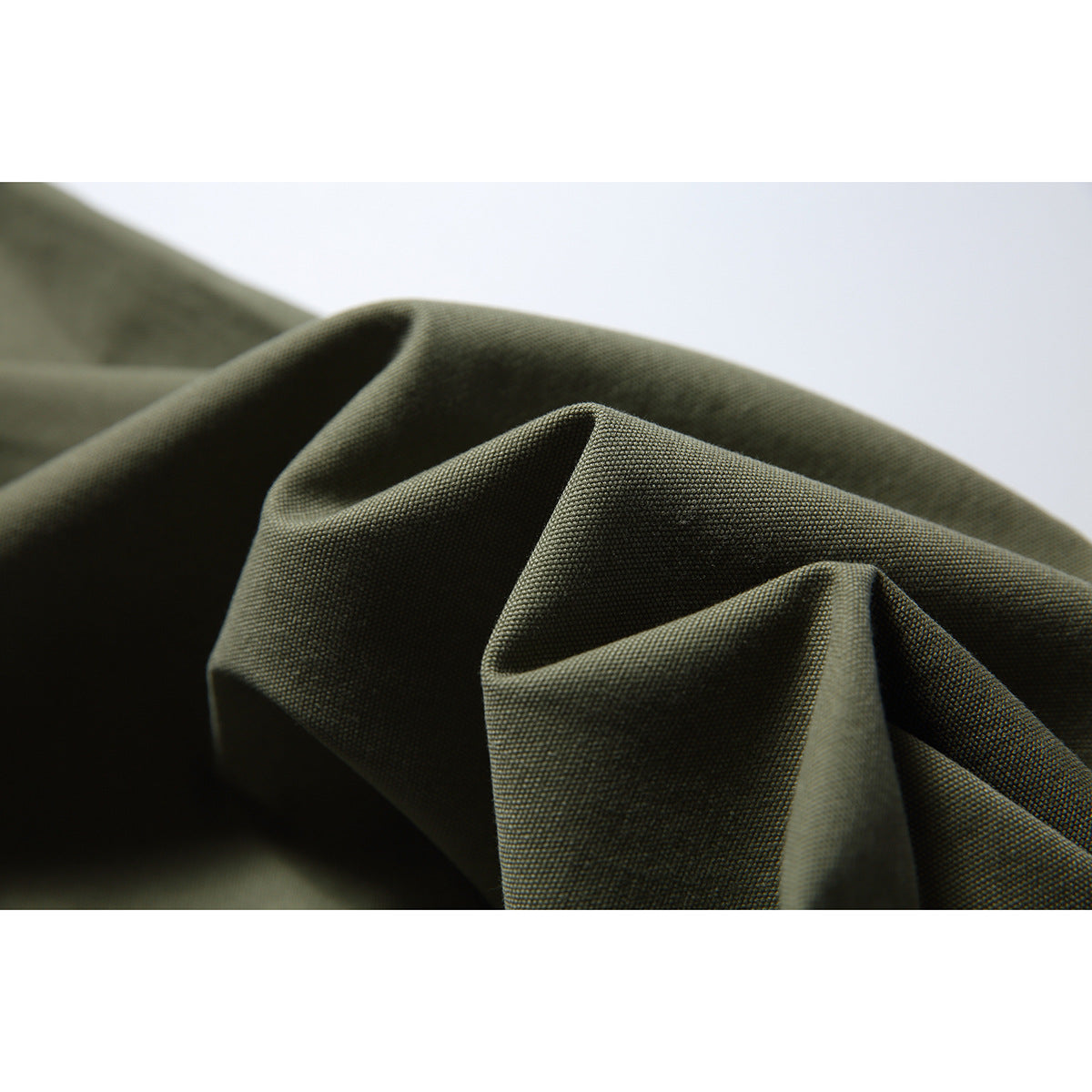 Close-up of folded olive-green trouser fabric showing its visible surface texture.