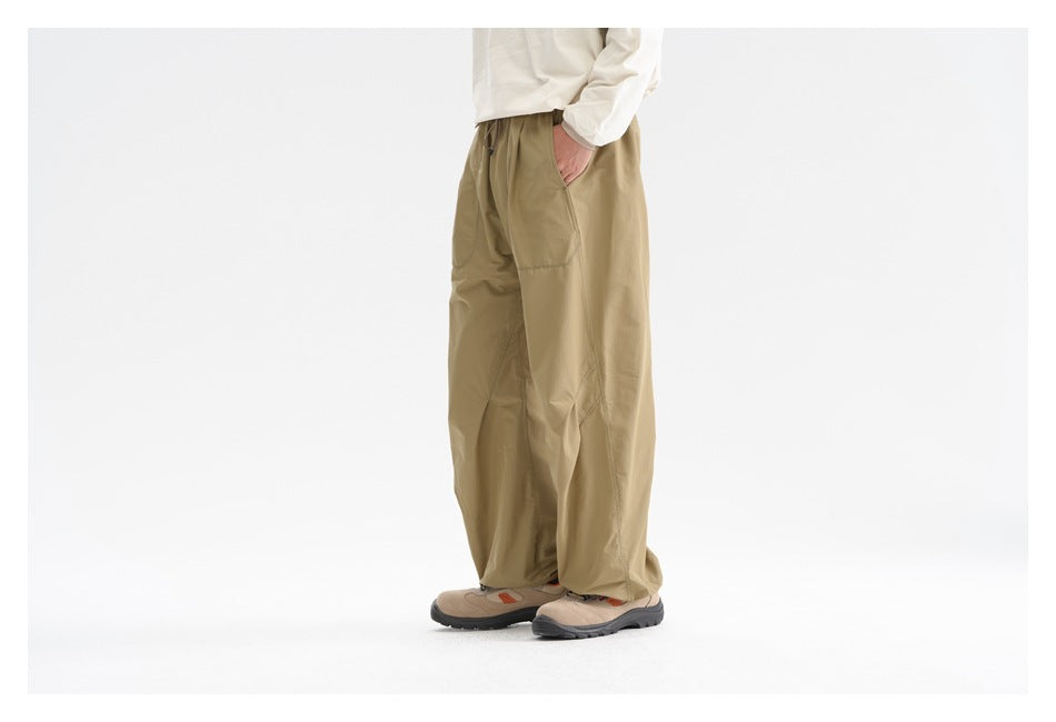 Side view of a model wearing loose khaki pants with a side pocket.