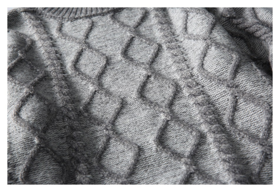 Close-up showing the gray sweater's raised geometric knit pattern and braided texture.