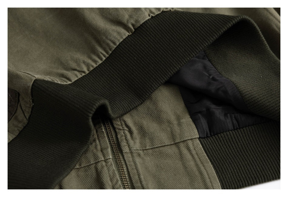 Close-up of an olive-green jacket with a zipper, dark ribbed trim and black lining.
